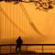 A man talks on his phone as he looks through the haze at the George Washington Bridge from Englewood Cliffs, N.J