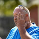 A man pauses to wipes his face while digging fence post holes in Houston June 27, 2023.