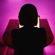 Image: Rear view of woman on laptop late at night