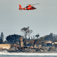 Image: A coastguard helicopter passing over damage caused by wildfires in Lahaina, Hawaii on Thursday, Aug. 10, 2023.
