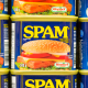 Spam canned meat stacked vertically in store shelf.