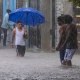 People walk through a street flooded by the rains of Tropical Storm Franklin in Santo Domingo, Dominican Republic