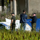 Russian servicemen inspect a part of a crashed private jet near the village of Kuzhenkino, Russia