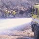 Fire crews work to stop the advancement of a brush fire that broke out Saturday, Aug. 26, 2023, in a neighborhood of Lahaina, Hawaii. 