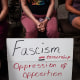 People sit with a sign at a Campbell County Library Board meeting