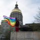 A demonstrator holds a Pride flag outside the Capitol in Atlanta to protest legislation that would prohibit most medical treatments to minors that help affirm gender identity on March 20, 2023.