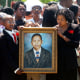 Donnell Jackson,13, left, and Shirley Floyd, right, hold up a portrait of Virgil Ware as members of Ware's family stand behind it during a memorial ceremony for Ware in Birmingham, Ala.,