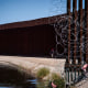 A man walks between a canal carrying water from the Colorado River and a border wall separating San Luis Rio Colorado, Mexico with San Luis, Ariz., on Aug. 14, 2022, in San Luis Rio Colorado, Mexico.