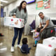 Monse Delgado (left) picks up diapers for her one year old Joe Yohander (middle) as Lupita Mendoza (right) waits for diapers for her one year old Jimena Sarci Rivas (with bottle) at the child care resource desk of the SF Human Services  Agency on Friday, Nov. 22, 2019, in San Francisco, Calif.  San Francisco this month became the first county in the US to hand out free diapers with its SNAP (food stamp) benefits.