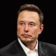 A portrait of Elon Musk against a black background.