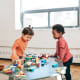 Two toddlers playing with toys at a daycare center. 