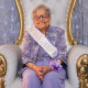 Elizabeth Eley sits on a chair with sash that reads,"100 & fabulous"