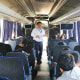Migrant children and teenagers sit on a charter bus as a member of the Guatemalan Institute of Migration speaks