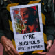 A protestor holds a sign with a photo of Tyre Nichols