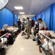 A hospital hallway is lined with injured patients and internally displaced people