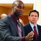 Gov. Ron DeSantis looks at Joseph Ladapo speak at a news conference in West Palm Beach, Fla.,
