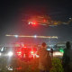 People wait at a helipad as a helicopter carrying released hostages lands