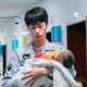 A man holds a child suffering from a respiratory illness.