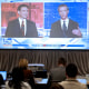 Ron DeSantis, left, and Gavin Newsom on a screeen during a debate held by Fox News, in Alpharetta, Ga.,