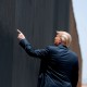 Donald Trump points to the border wall.