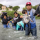 Immigrants from Venezuela cross the Rio Grande from Mexico into the United States in Eagle Pass, Texas. 