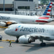 American Airlines passenger jets prepare for departure on July 21, 2021, near a terminal at Boston Logan International Airport.