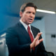 Ron DeSantis speaks with reporters during an interview in Des Moines, Iowa.