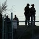 Texas troopers stand near a "No Trespassing" sign and concertina wire