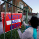 Election worker Ramona Ortiz places a sign outside a polling station 