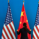 A woman adjusts a flag during the U.S.-China Strategic and Economic Dialogue in Beijing