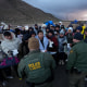 Agentes de la Patrulla Fronteriza hablan con migrantes que buscan asilo en un campamento montañoso improvisado después de cruzar la frontera desde México el viernes 2 de febrero de 2024, cerca de Jacumba, California.