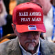 A man wears a 'Make America Pray Again' hat