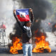 A demonstrator holds up an Haitian flag.