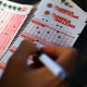 A customer fills out a Mega Millions and Powerball ticket
