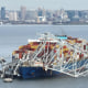 The steel frame of the collapsed Francis Scott Key Bridge sits on top of a container ship, in Baltimore