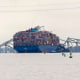 A container ship rests against wreckage of the Francis Scott Key Bridge in Baltimore, Md.