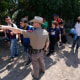 Un agente del Departamento de Seguridad Pública de Texas frente a un grupo de migrantes en Del Rio, el 30 de julio de 2021.