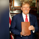Fotografía promocional del expresidente Donald Trump mientras posa con un ejemplar de la Biblia de Estados, que está vendiendo por 59.99 dólares.