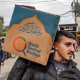 A man carries a cardboard box of food aid provided by World Central Kitchen in Rafah, Gaza