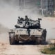 An Israeli soldier moves atop a tank near the Israeli-Gaza border