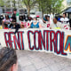 A protest banner reads "Rent Control Now"