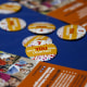 Census 2020 pins and leaflets are displayed on a table during a community food distribution at a YMCA location in Los Angeles