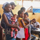 People wait to be treated by health workers at a mobile health clinic organized by UNICEF and Medecins du Monde for people displaced by gang violence in Port-au-Prince on March 26, 2024.