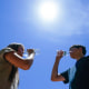 Giselle Berastegui and her brother Tony drink water in Phoenix during a heat wave