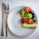 Vegetables and fruits on a plate on a light background