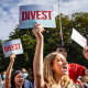 Students from New York University hold "Divest" signs during a rally