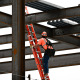A construction worker climbs a ladder.