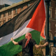 A protester places a Palestinian flag at a pro-Palestinian encampment at Columbia University, in New York, Sunday, April 28, 2024.