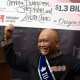 Cheng Saephan levanta un cheque después de hablar en una conferencia de prensa el lunes 29 de abril de 2024 en las oficinas de la Lotería de Oregon, en Salem, Oregon.