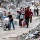 Displaced Palestinians evacuate along a road of rubble